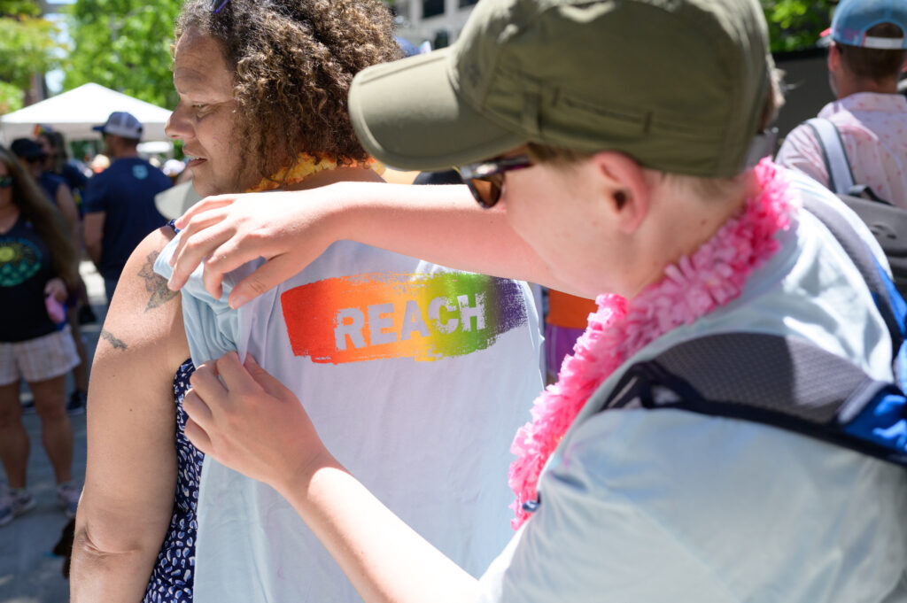 Maggie (LEAD Case Manager) displays the REACH Pride t-shirt.