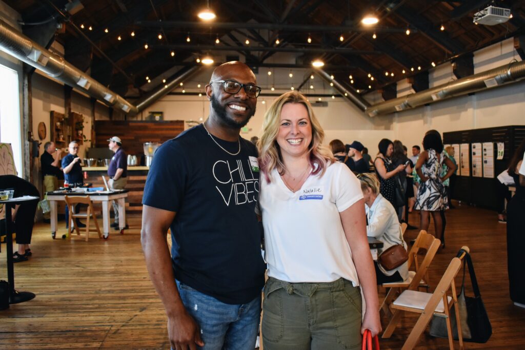 Two staff members smile for a picture.