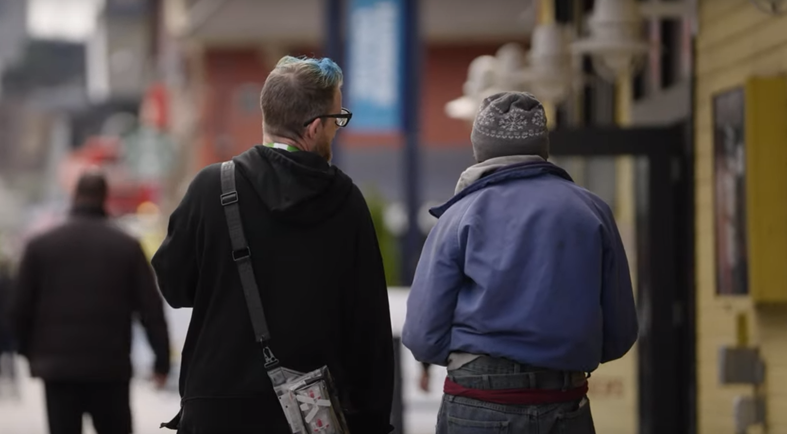 A REACH staff walks alongside a person near Seattle's Waterfront Park.